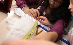 Two students work together to measure a 3-D printed dinosaur bone.