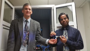 Michael Free (left) holds a light emitting diode and Prashant Sarswat (right) holds carbon dots in suspension.